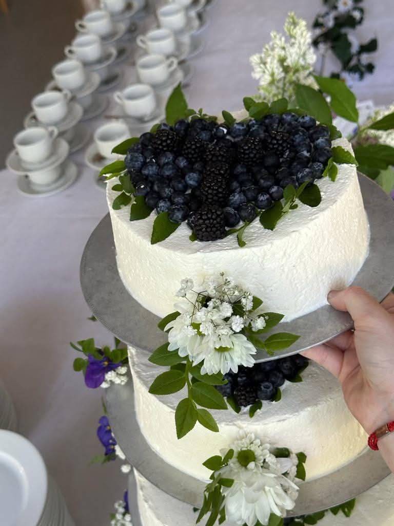 Valkoinen kerroskakku mustikoilla ja kukilla